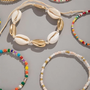 Detail of bohemian shell bracelets and colorful bead bracelets for summer beach style