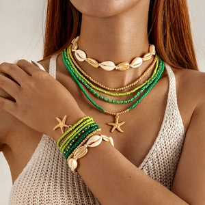 Detail of Bohemian shell jewelry set with green beads and starfish charm on model