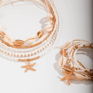 Detail of bohemian shell necklace and starfish charm bracelet with white resin beads