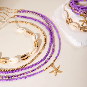 Close-up of bohemian shell jewelry set with purple beads and starfish pendants