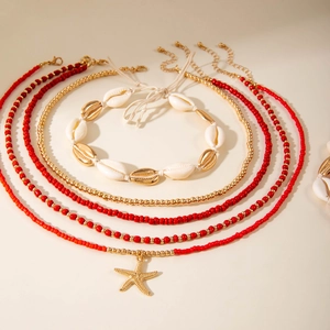Detail of bohemian layered necklace set with shell accents and golden starfish charm