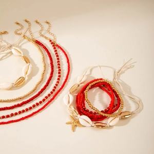 Detail of bohemian shell necklace and starfish beaded bracelet with natural conch charms