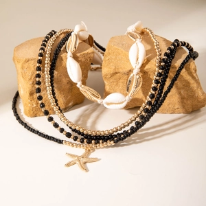 Detail of bohemian shell necklace with gold starfish charm and beaded layers