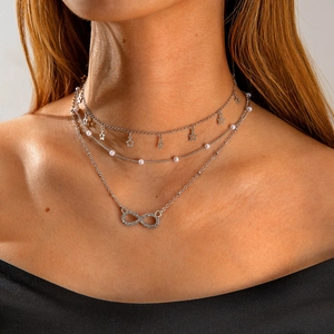 Three-layer silver necklace with star charms, white pearls and infinity symbol pendant