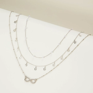 Three-layer silver necklace with infinity symbol, star charms and faux pearls on white base