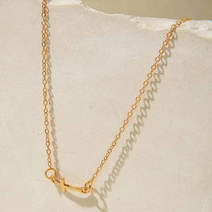 Macro detail of gold-plated cross pendant on fine O-chain jewelry for women