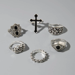 Detail view of a 6-piece gothic ring set with cross, skull, and eagle motifs in antique silver
