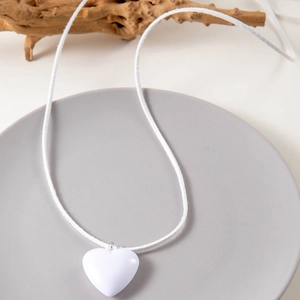 Layered velvet cord necklace with minimalist white heart pendant and elegant bow design