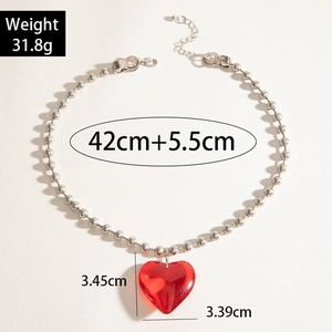 Detalle del colgante de corazón rojo y el collar de cuentas plateadas con medidas exactas
