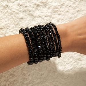 Close-up of bohemian black multi-layer beaded bracelets with faceted beads on wrist