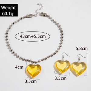 Vista detallada del conjunto de collar con colgante de corazón amarillo y pendientes