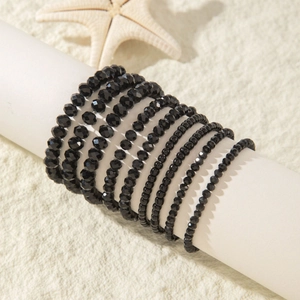 Close-up of bohemian multi-layer black faceted bead bracelets set on a display stand