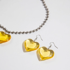 Detalle de colgantes de corazón amarillo vibrante y conjunto de collar plateado