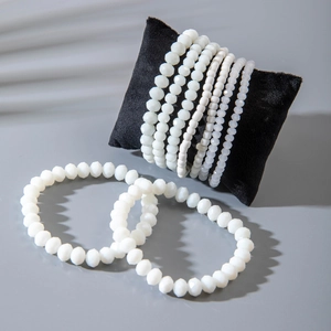 Detail of bohemian white faceted bead bracelets on a black velvet display pillow