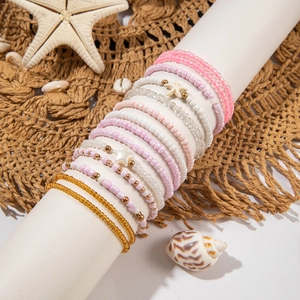 Detail of multi-layer pink seed bead bracelets with starfish and shell beach charms