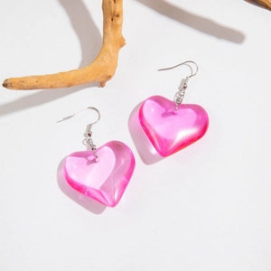 Detailed view of pink heart-shaped resin earrings with elegant silver hooks