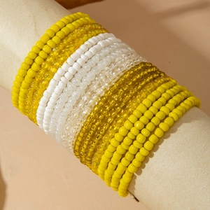 Close-up of bohemian multilayer beaded bracelet featuring yellow and white resin beads