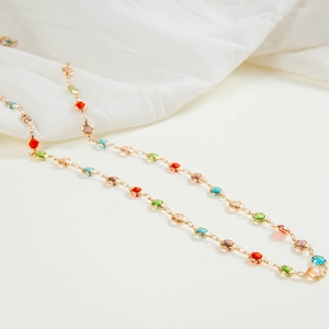 Detalle de cuentas facetadas de colores en un collar de cadena en Y chapado en oro