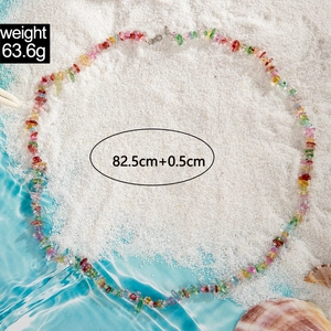 Detalle de collar de cuentas coloridas en la arena con conchas, largo de 82.5cm