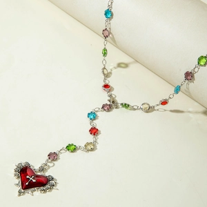 Detail of beaded tassel necklace with heart gemstone and silver rose carvings