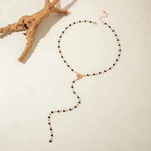 Detailed shot of double layer Y-necklace with black beads and gold coin pendant