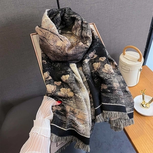 Gros plan d'un châle pashmina à fleurs montrant le tissu doux et les détails des franges