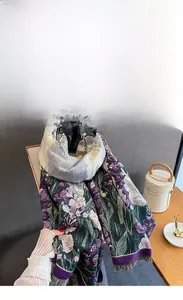 Dettaglio di sciarpa floreale in finto cashmere con nappe viola e trama in tessuto morbido