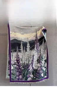 Dettaglio di sciarpa con stampa paesaggistica floreale, fiori viola e bordi a frange
