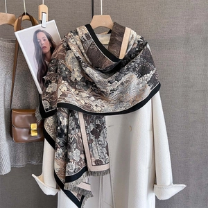 Sciarpa pashmina vintage con stampa floreale e frange su un cappotto di lana bianco