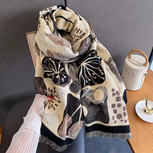 Dettaglio di sciarpa jacquard invernale con motivi floreali astratti e frange