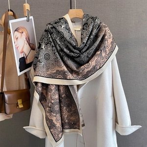 Detail of vintage scroll pattern scarf with tassel edge on white coat in elegant setting