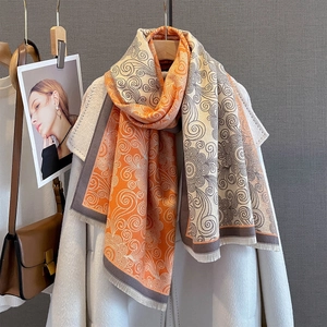 Detail of multi-color scarf featuring scroll patterns and delicate short fringe edges