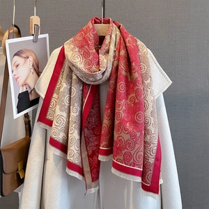 Detail of red and white paisley scarf with fringe paired with white coat and leather bag