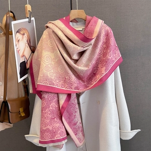 Pink and cream jacquard scarf with swirl texture and fringe on a white coat