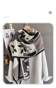 Detailed view of imitation cashmere scarf with floral print and fringe on a hanger