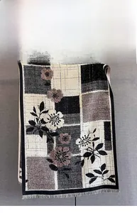 Detailed view of autumn cashmere-feel scarf with geometric plaid and floral print patterns