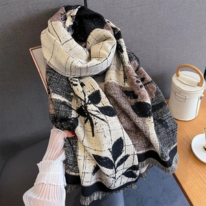 Detail of cashmere-like scarf showing leaf print, grid pattern and short fringe edge