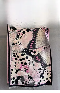 Détail d'une écharpe à motif papillon rose et noir avec de fines franges