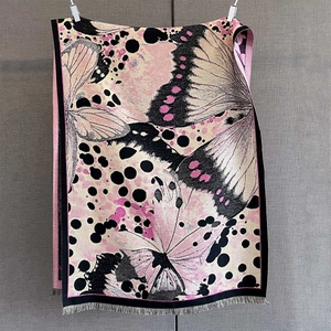Détail du châle pashmina avec imprimé ailes de papillon et bords à franges noires
