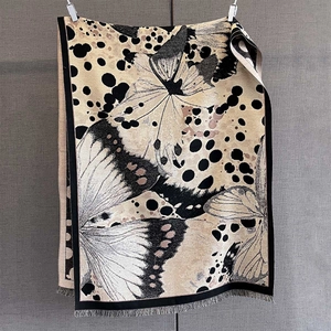 Détail d'un châle pashmina doux avec imprimés papillons vintage et longs pompons