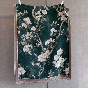 Detail showing jacquard texture of dark green floral cashmere pashmina shawl with tassels