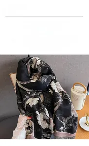 Detail of soft imitation cashmere scarf with elegant champagne floral prints and fringe