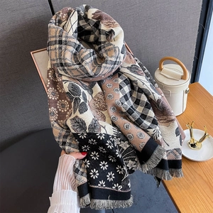 Close-up of vintage floral patchwork scarf with thick tassels and geometric texture
