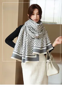 Détail d'une écharpe douce à motifs géométriques gris et blanc avec bords à franges