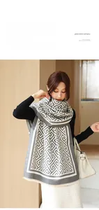 Détail d'un châle d'hiver doux avec motif géométrique gris et beige et bords effilochés