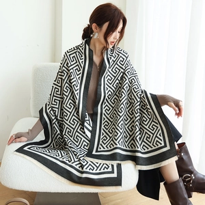 Détail d'un châle d'hiver doux avec motif géométrique classique noir et blanc et franges
