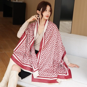 Détail d'un châle en cachemire bordeaux et beige avec motifs géométriques et franges