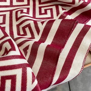 Détail macro du motif géométrique grec rouge et blanc sur le tissu de l'écharpe