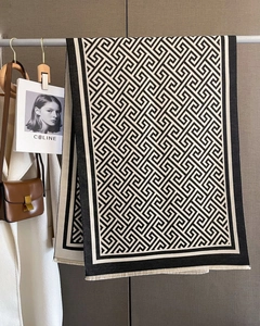 Détail d'une écharpe d'hiver douce avec motif grec noir et blanc et bords à franges