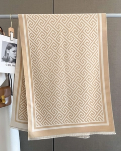 Détail d'une écharpe beige à motif clé grecque avec des bords effilochés